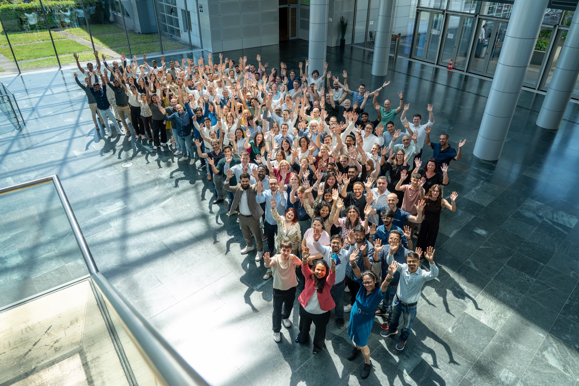 FrontWell colleagues gathered together in a bright manufacturing and technology environment.