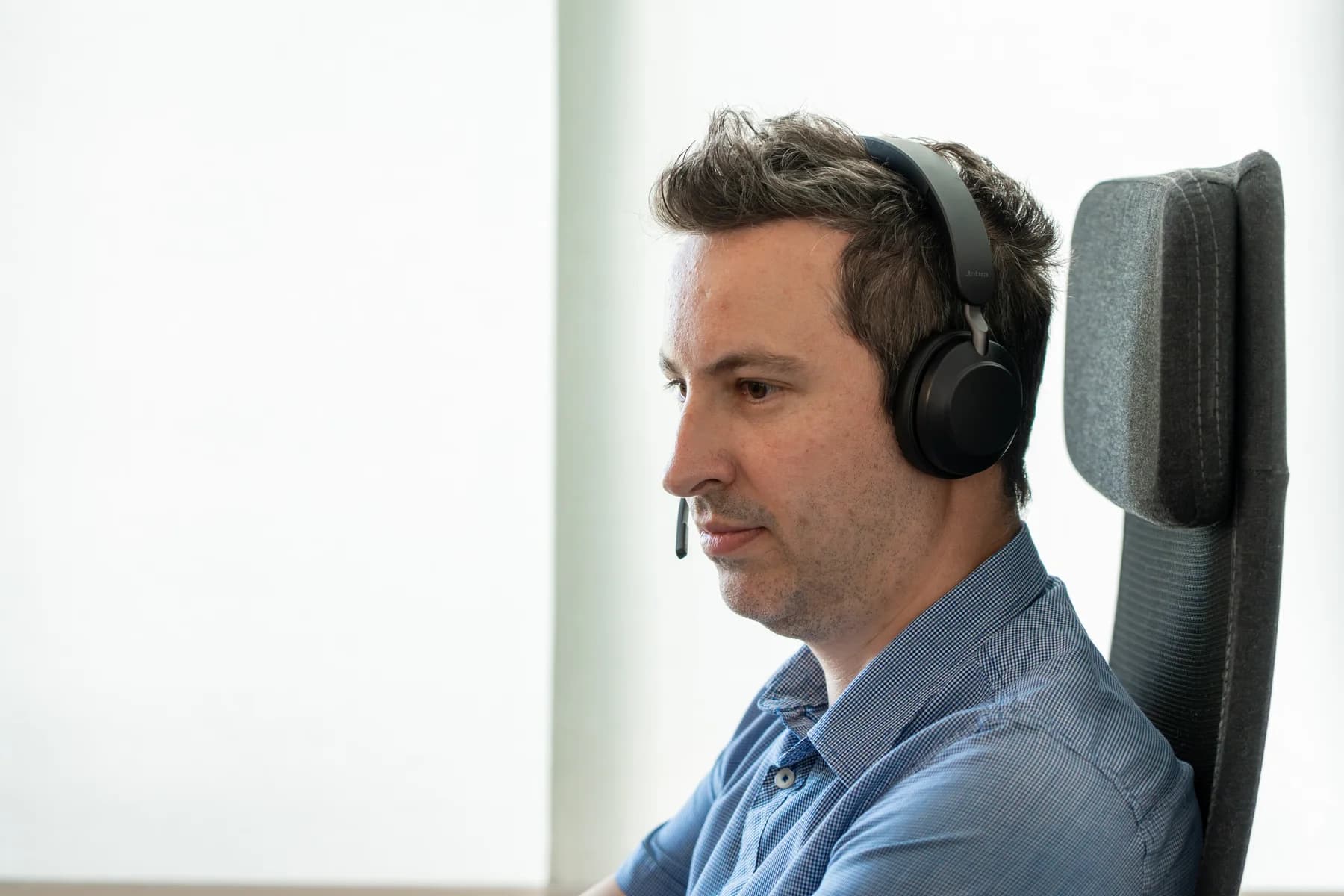 A FrontWell colleague working with a headset in a bright, quiet office setting.