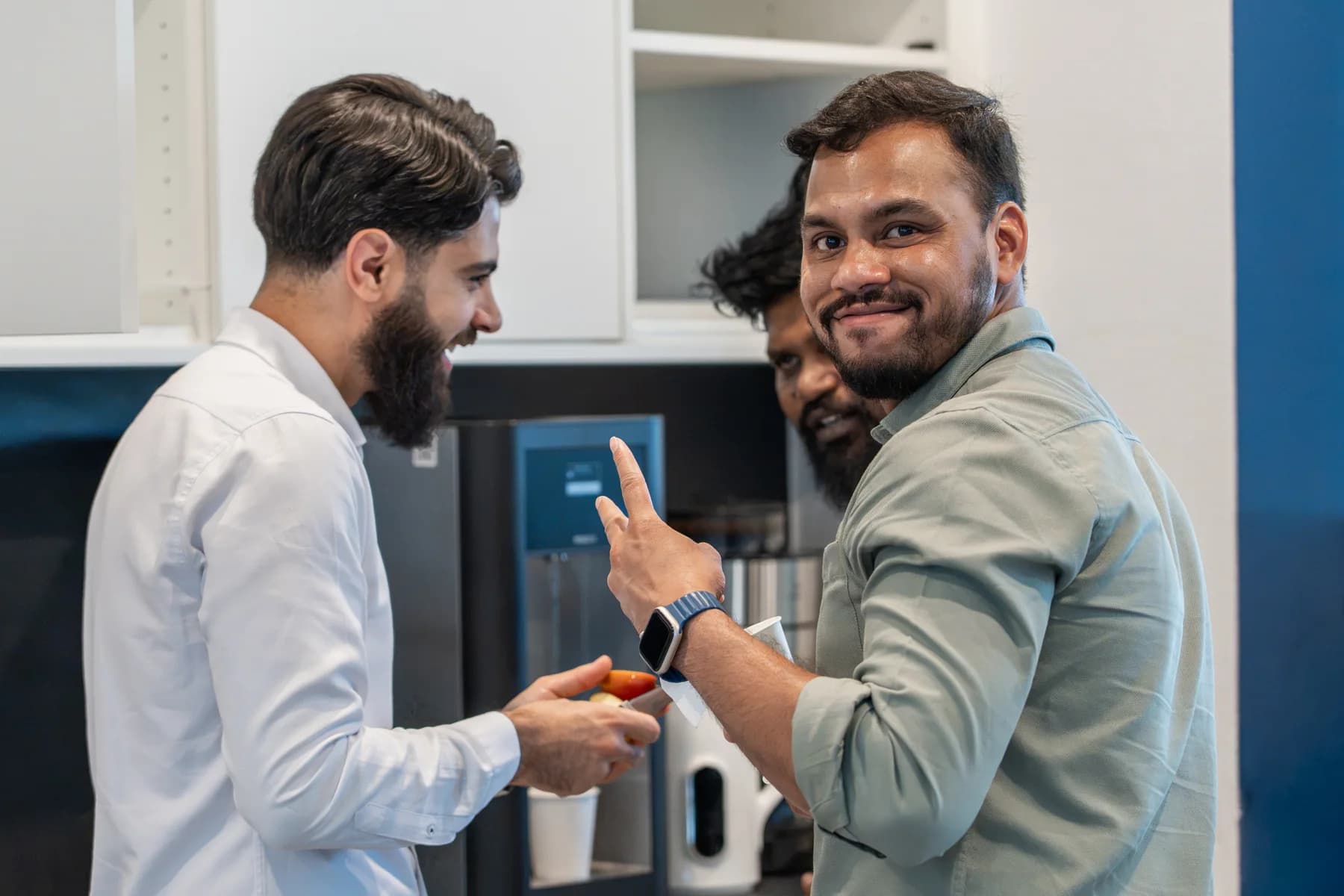 FrontWell colleagues chatting over coffee in the office kitchen.