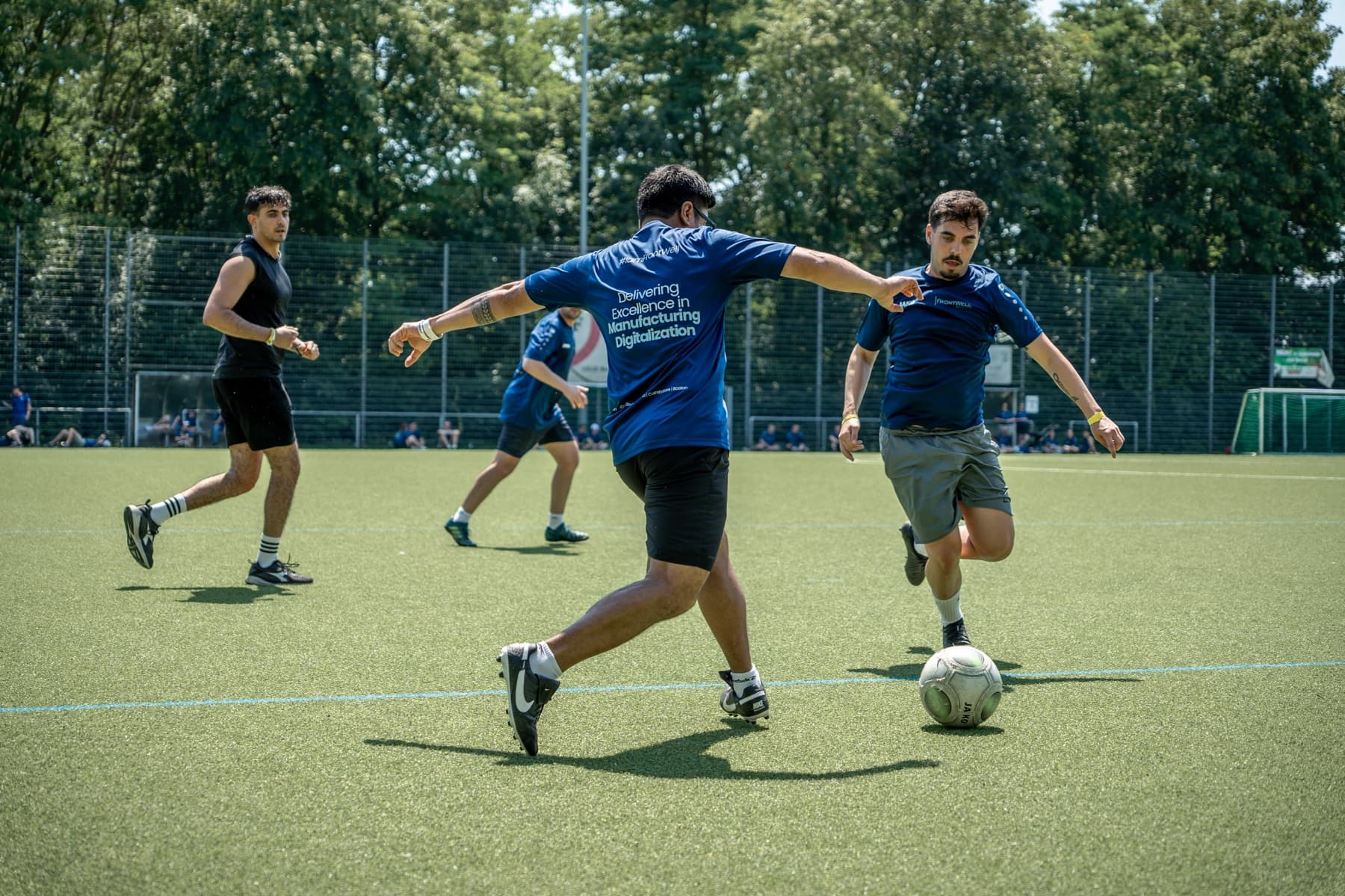 FrontWell colleagues playing football together on the field.