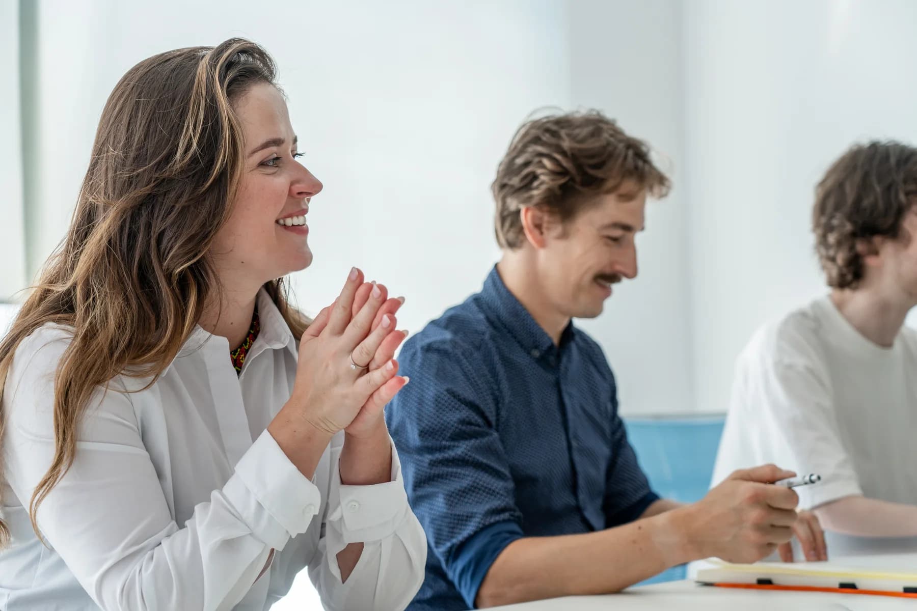 A FrontWell colleague smiling during a conversation at a meeting table.